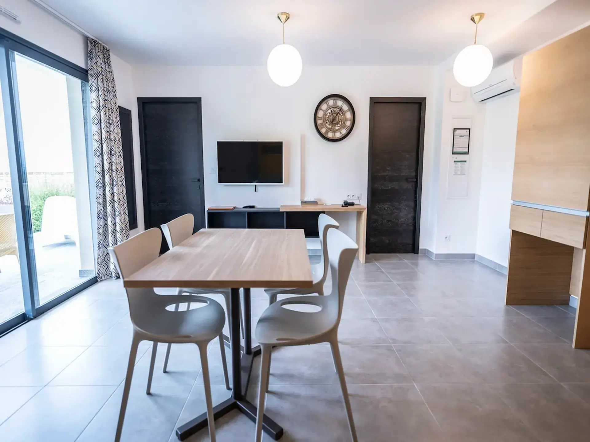 Séjour avec table, TV et terrasse appartement T2 Supérieur à Vescovato